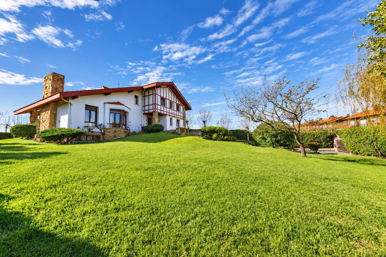 Casa Tudor entre césped y cielo azul